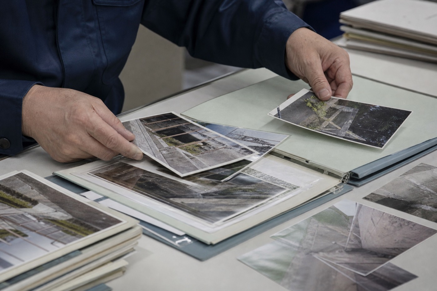 現場写真を仕分けしてファイルに整理する手元