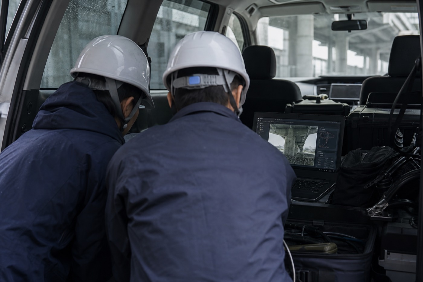 現場車両内でノートPCの点検データを確認する技術者
